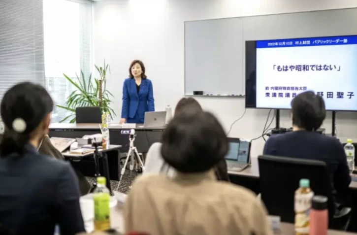 La députée et ancienne ministre nippone Seiko Noda (arrière-plan) fait cours dans le cadre d'un programme de mentorat pour aider les femmes japonaises à se lancer en politique, le 10 décembre 2022 à Tokyo ( AFP / Philip FONG )