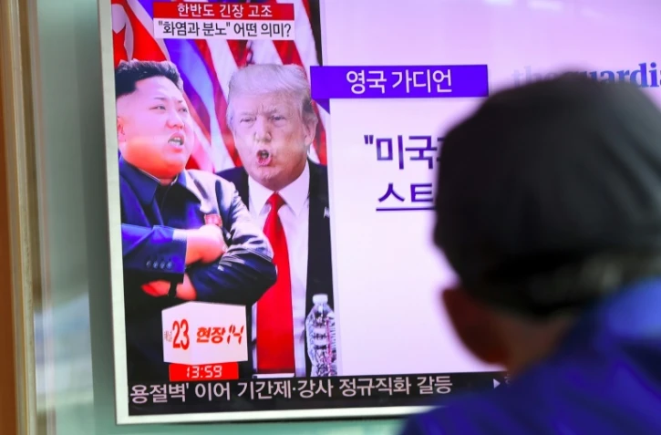 Des portraits du leader nord-coréen Kim Jong-Un (g) et du président américain Donald Trump (d) sur un écran de télévision, le 9 août 2017 à Séoul