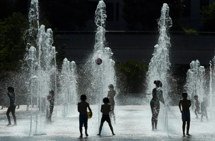 Des enfants dans des jets d'eau au Parc André Citroën à Paris le 26 juillet 2018