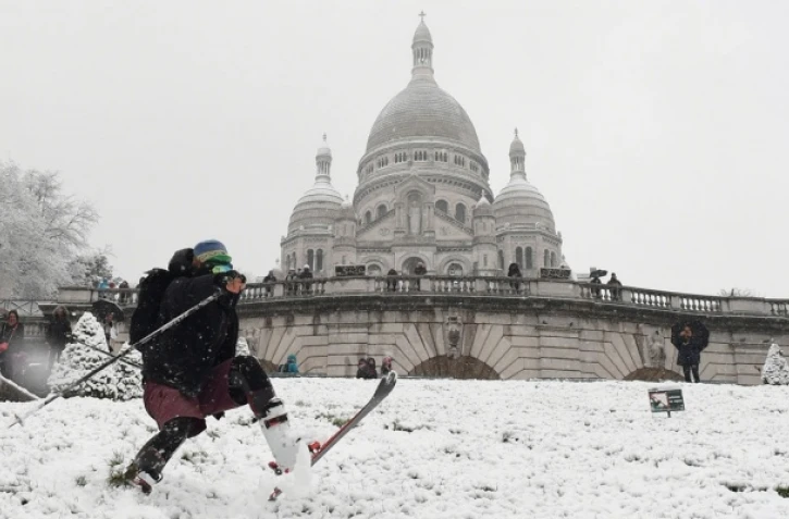 Des promeneurs sur l\'esplanade du Trocadéro recouverte de neige, face à la Tour Eiffel, le 6 février 2018 à Paris