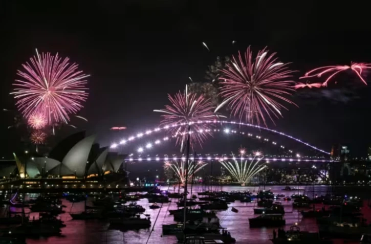 Le « feu d'artifice familial » illumine l'Opéra et le pont du port de Sydney trois heures avant le spectacle principal, à minuit à Sydney, le soir du Nouvel An, le 31 décembre 2025 ( AFP / Saeed KHAN )