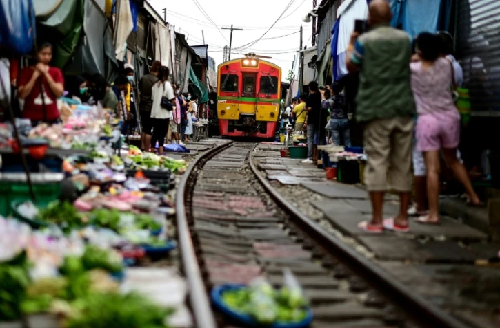 Un train de passagers traverse le marché de Maeklong dans la province de Samut Songkhram, le 4 juin 2022 en Thaïlande