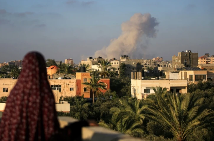 Une Palestinienne regarde de la fumée s'élever après une frappe isaélienne au sud de la ville de Gaza le 11 juin 2024