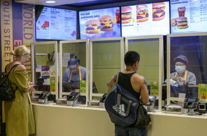 Des employés d'un  McDonald's à New York, le 27 mai  2022. Des salariés de fast-food ont manifesté à Manhattan pour demander un salaire de 20 dollars par heure, une revendication impensable avant la pandémie mais avec la pénurie de main d'oeuvre aux Etats-Unis, les entreprises ont augmenté les bas salaires.