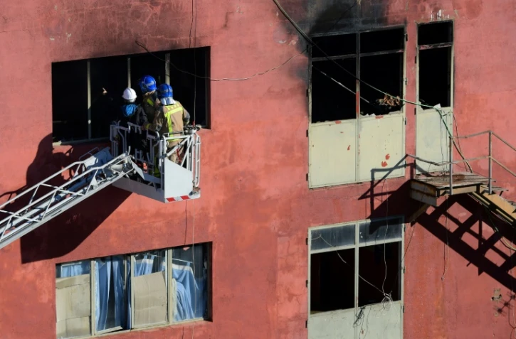 Des pompiers inspectent un entrepôt où s'est déclaré un incendie, le 10 décembre 2020 à Badalona, près de Barcelone