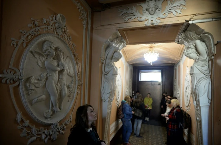 Des personnes découvrent une entrée d'immeuble d'époque lors d'une visite guidée, le 15 avril 2018 à Saint-Pétersbourg