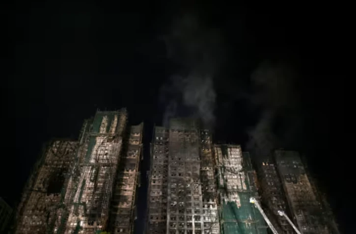 Les tours fumantes du complexe résidentiel Wang Fuk Court où un incendie s'est déclaré la veille, le 27 novembre 2025 à Hong Kong ( AFP / Philip FONG )