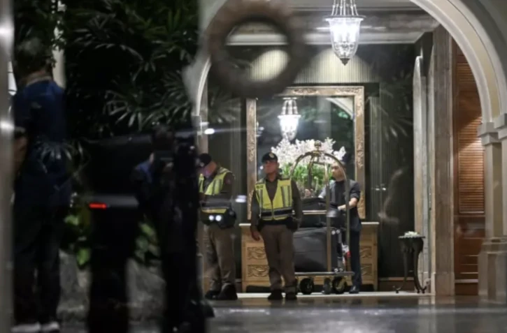Des policiers dans le hall d'entrée d'un hôtel après la découverte de six corps, le 16 juillet 2024 à Bangkok, en Thaïlande ( AFP / Lillian SUWANRUMPHA )
