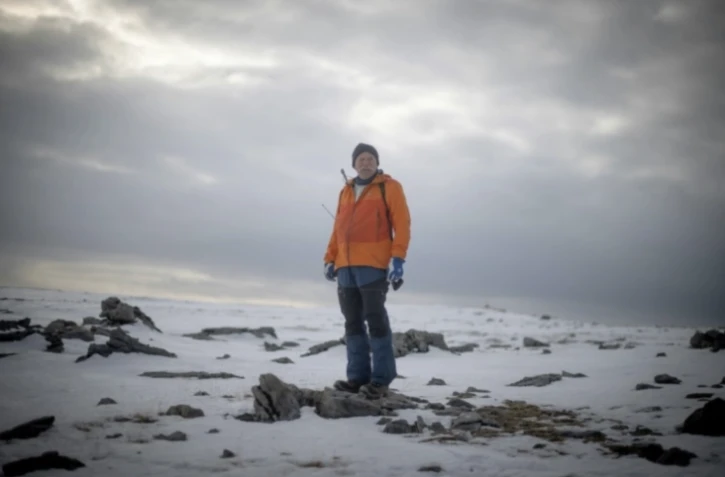 Le météorologue norvégien Trond Robertsen patrouille avec un fusil en cas d'attaque d'ours polaire, à la station météorologique de la côte nord du territoire norvégien isolé de l'île aux Ours (Bjornoya), Le 5 avril 2025 ( AFP / Olivier MORIN )