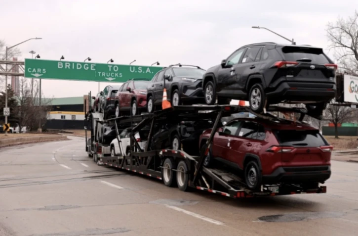 Un transporteur de voitures transporte des véhicules Toyota RAV4 sur le point de passer de Windsor (Ontario), au Canada, à Detroit (Michigan), aux Etats-Unis, le 3 février 2025 ( AFP / JEFF KOWALSKY )