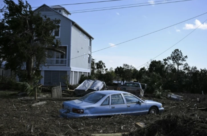 Des débris entourant une voiture après le passage de l'ouragan Hélène, à Steinhatchee, en Floride, le 27 septembre 2024 ( AFP / CHANDAN KHANNA )