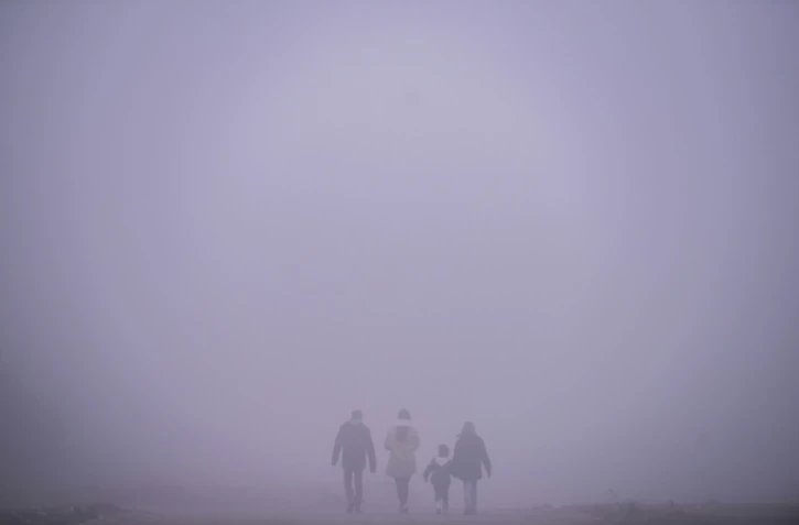 Quatre personnes marchent près de Pristina au moment où la capitale du Kosovo connaît un fort taux de pollution, le 9 janvier 2022