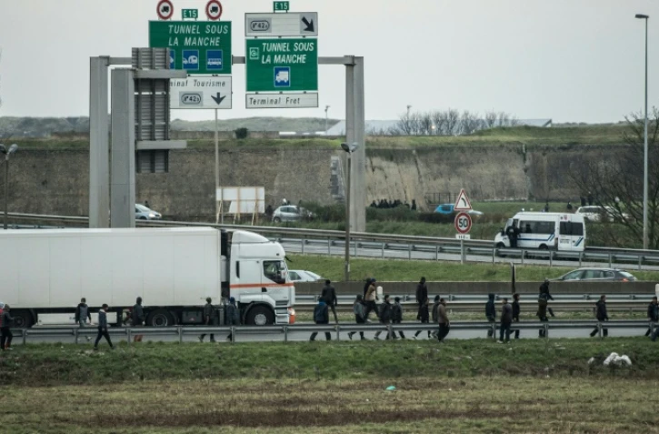 Des migrants marchent sur l'autoroute A16, le 3 décembre 2015 à Coquelles, dans le Pas-de-Calais