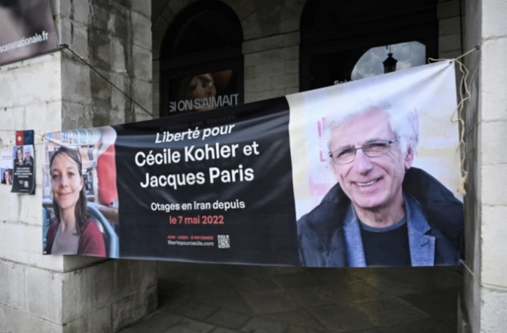 Une banderole représentant les Français Cécile Kholer et Jacques Paris détenus en Iran, lors d'un rassemblement pour leur libération, devant la mairie de Bayonne, le 7 mai 2025 ( AFP / Gaizka IROZ )
