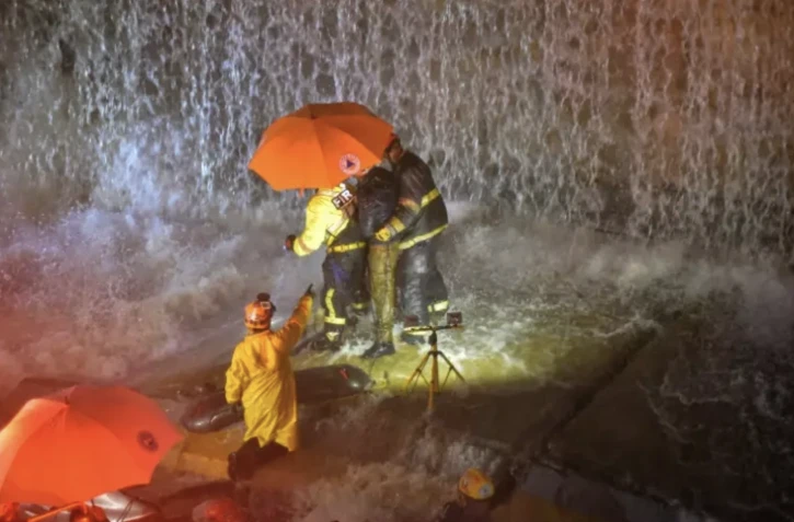Des sauveteurs recherchent des personnes coincées sous un mur qui s'est effondré sur plusieurs véhicules après de fortes pluies sur l'avenue 27 Février de Saint Domingue, le 18 novembre 2023 ( AFP / Felix Leon )