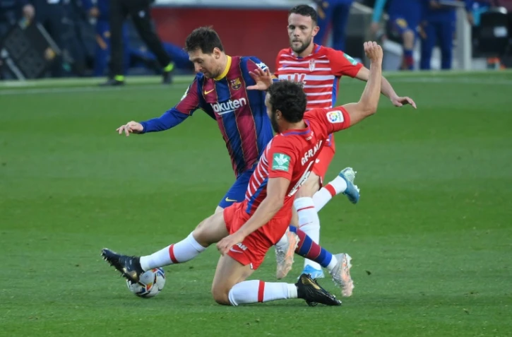 La star du Barça Lionel Messi taclé par le défenseur de Grenade German Sanchez, le 29 avril 2021 à Barcelone