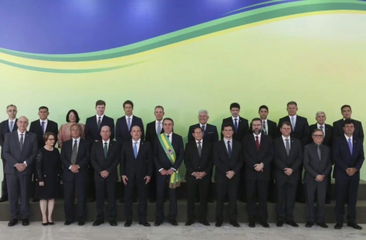 Le président brésilien Jair Bolsonaro, ceint de l'écharpe présidentielle, entouré de ses ministres, au palais du Planalto à Brasilia, le 1er janvier 2019