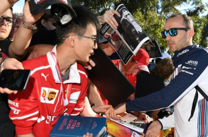 Le pilote de F1 polonais Robert Kubica (d) signe des autographes, le 23 mars 2018 à Melbourne