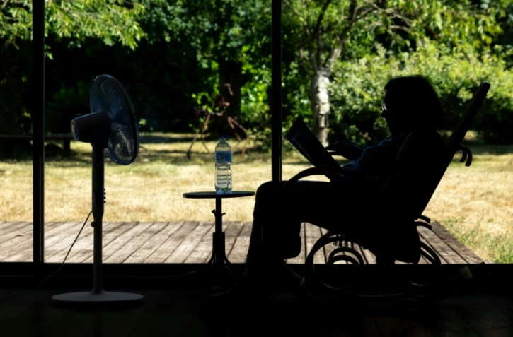 Une personne âgée assise face à un ventilateur à Pont-Audemer, dans l'Euroe, le 12 juillet 2026 lors d'une vague de chaleur en France