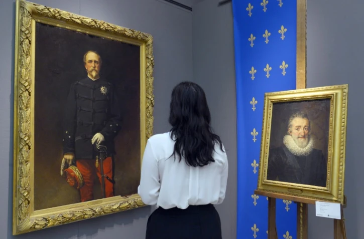 Une femme regarde un peinture d'Henri d'Orléans (G) et du roi Henri IV chez Sotheby's à Paris le 18 septembre 2015