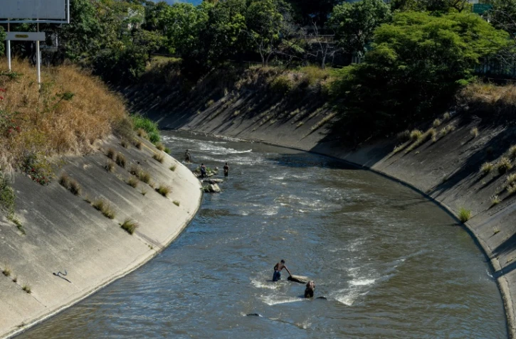 De jeunes Vénézuéliens dans les eaux sales du fleuve Guaire de Caracas au Venezuela, le 1er février 2018