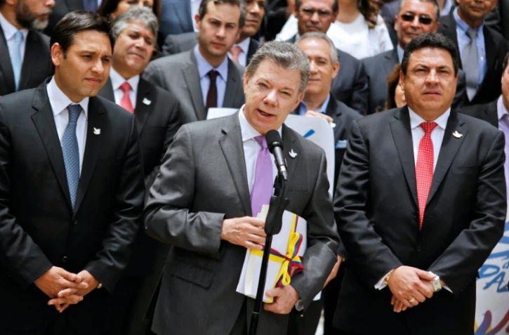 Le président colombien Juan Manuel Santos tient une copie de l'accord de paix avec les FARC, à Bogota, le 25 août 2016