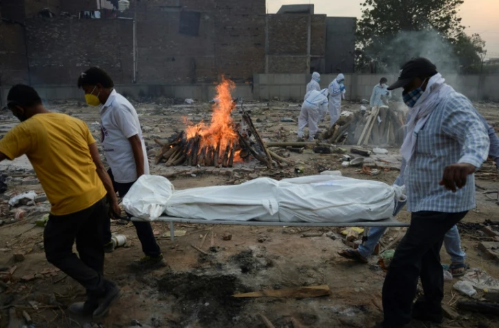 Des proches assistent à la crémation d'une personne décédée du Covid-19 au crematorium de New Delhi le 11 mai 2021
