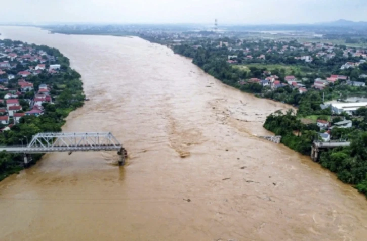 Vue aérienne du pont de Phong Chau, effondré sur le fleuve Rouge, dans la province de Phu Tho au Vietnam le 9 septembre 2024, après que le super typhon Yagi a frappé le nord du pays ( AFP / STR )