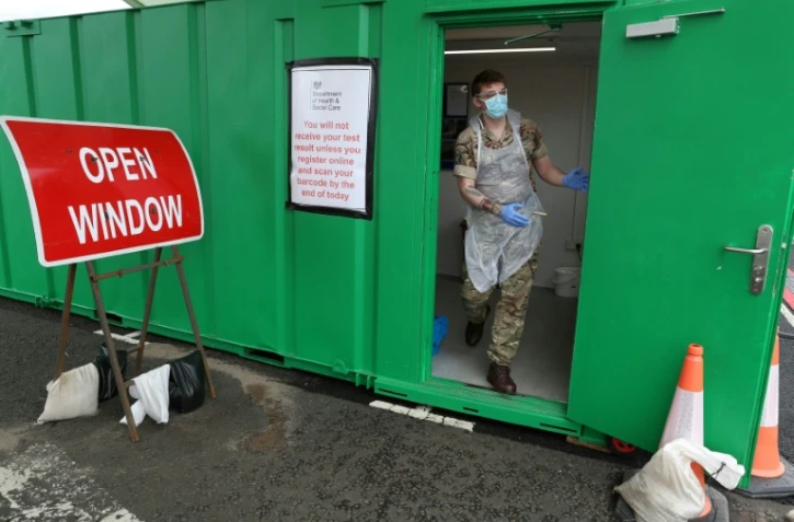 Un militaire s'apprête à réaliser des prélèvement de test au coronavirus en "drive" à l'aéroport de Glasgow le 29 avril 2020
