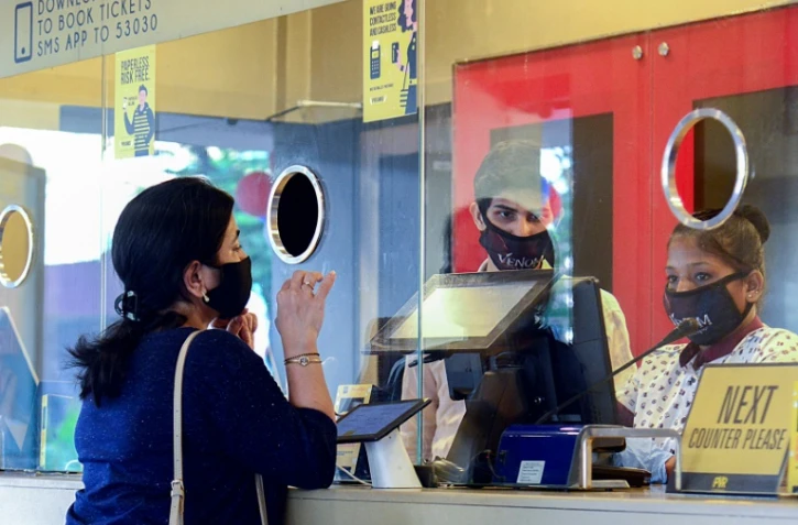 Une cinéphile achète des billets au guichet d'un cinéma de Bombay le 22 octobre 2021