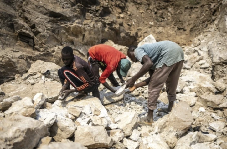 Des mineurs ramassent des pierres contenant du lithium sur un site minier à Gidan Kwano, dans l'État de Nasarawa, le 23 janvier 2025 au Nigeria ( AFP / OLYMPIA DE MAISMONT )