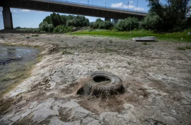 Un pneu git dans le cours du Danube asséché, près du pont Vidin-Calafat qui relie la Bulgarie et la Roumanie, au niveau du village d'Antimovo, dans le sud-est de la Bulgarie, le 22 juillet 2026 ( AFP / Nikolay DOYCHINOV )