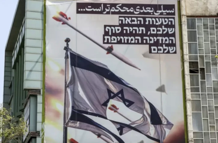 Une affiche sur la place de Palestine à Téhéran proclame en farsi: "la prochaine gifle sera plus dure", et en hébreu: "votre prochaine erreur marquera la fin de votre Etat fantoche", le 14 avril 2024 ( AFP / ATTA KENARE )