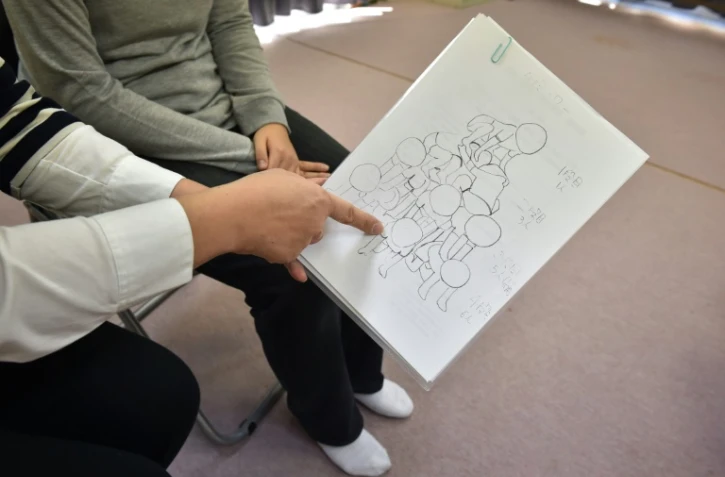 La mère d'une fillette explique avec un croquis comment blessée lors d'une classe le 11 novembre 2015 à Tokyo 