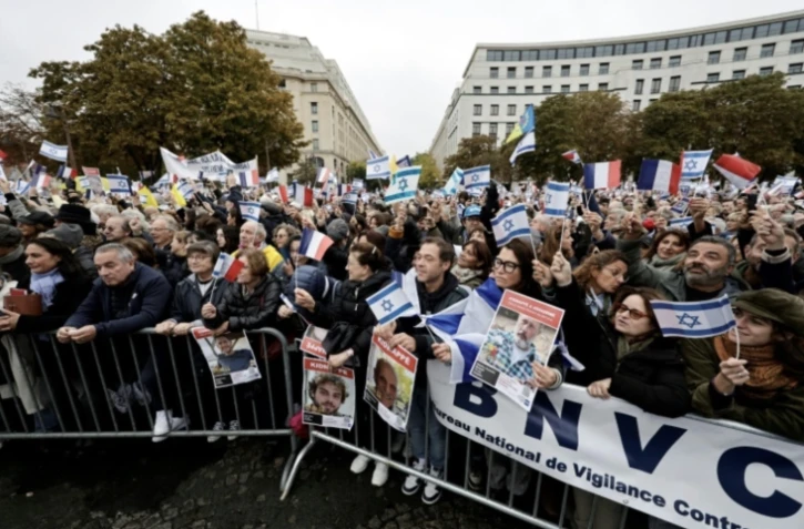 Des manifestants brandissent des drapeaux israéliens et des portraits d'otages retenus par le Hamas dans la bande de Gaza, le 6 octobre 2024 à Paris, lors d'un rassemblement de soutien à Israël et aux victimes de l'attaque du 7 octobre 2023 ( AFP / STEPHANE DE SAKUTIN )
