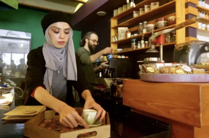 Le propriétaire Ihsane al-Azmeh (d) prépare du café dans son établissement à Damas, le 30 janvier 2023 en Syrie ( AFP / LOUAI BESHARA )