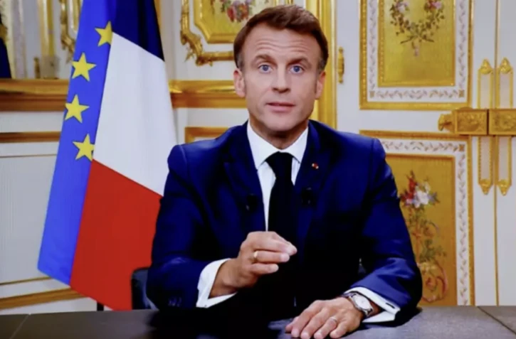 Le président Emmanuel Macron vu sur un écran de télévision lors d'une allocution télévisée le 12 octobre 2023, à Paris ( AFP / Ludovic MARIN )