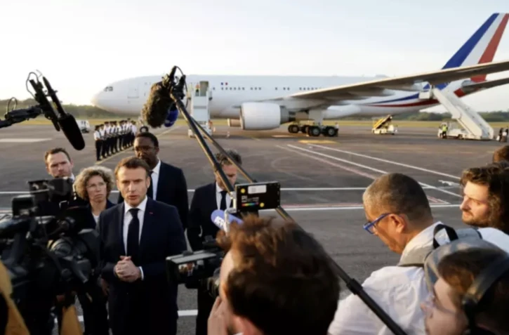 Le président Emmanuel Macron fait une déclaration à la presse à son arrivée à l'aéroport de Cayenne, le 25 mars 2024 en Guyane ( AFP / Ludovic MARIN )