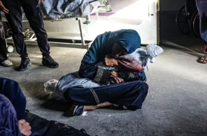 Une Palestinienne serre le corps d'un enfant dans une clinique, le 26 mai 2024 à Rafah dans la bande de Gaza ( AFP / Eyad BABA )