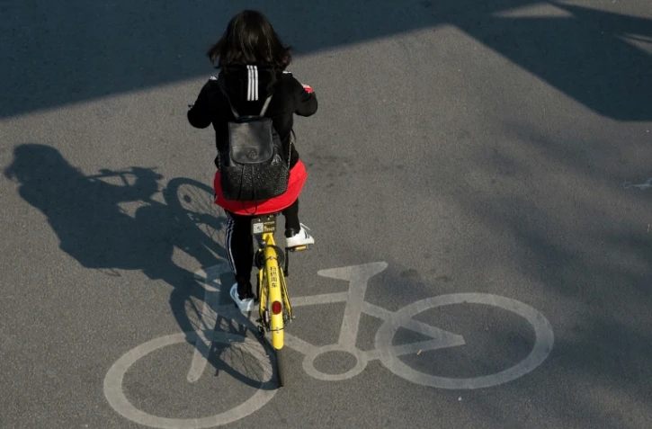 Une femme sur un vélo partagé à Pékin le 28 mars 2017