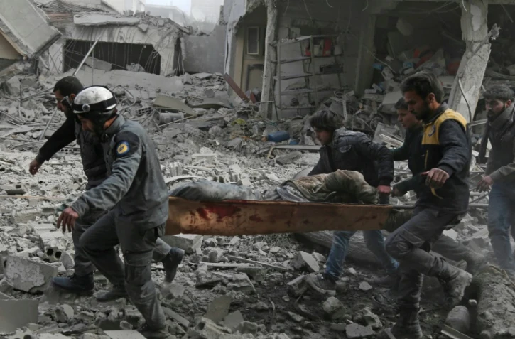 Un homme blessé évacué par des forces de défense civiles sur un brancard, dans la région de la Ghouta, près de Damas, le 20 février 2018