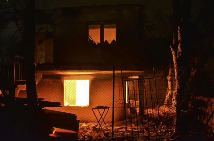 Une maison en feu le 23 juillet 2018 à Mati, petite station balnéaire proche d'Athènes, ravagée par les incendies qui ont fait au moins 50 morts