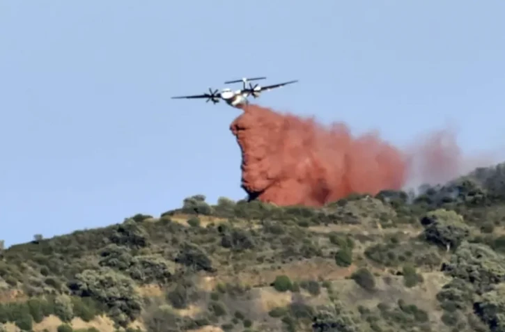 Un avion largue un produit retardant sur le feu à proximité de Banyuls-sur-Mer le 16 avril 2023 ( AFP / RAYMOND ROIG )