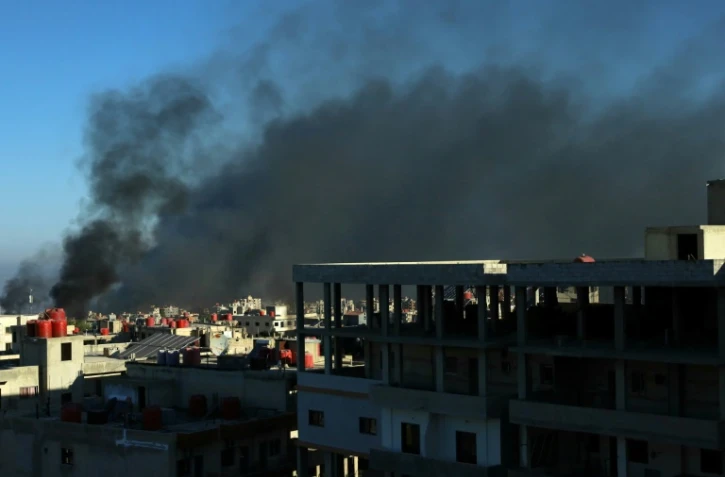 De la fumée noire s'élève au-dessus des bâtiments dans la ville de Soueida, dans le sud de la Syrie, aprè des affrontements communautaires, le 19 juillet 2025