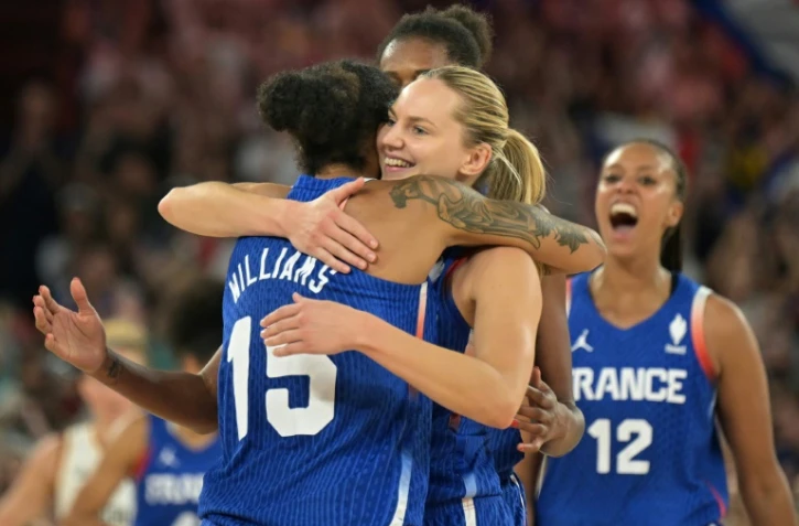 Gabby Williams (G) et Marine Johannes (D) s'enlacent après la qualification des Bleues du basket pour les demi-finales du tournoi olympique, le 7 août 2024 à Bercy
