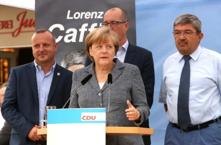 La chancelière allemande Angela Merkel à côté du ministre de l'Intérieur de Mecklembourg-Poméranie occidentale Lorenz Caffier (droite) et le candidat de la CDU Christian Democratic, lors d'un meeting de campagne à Bad Doberan (est), le 3 septembre 2016