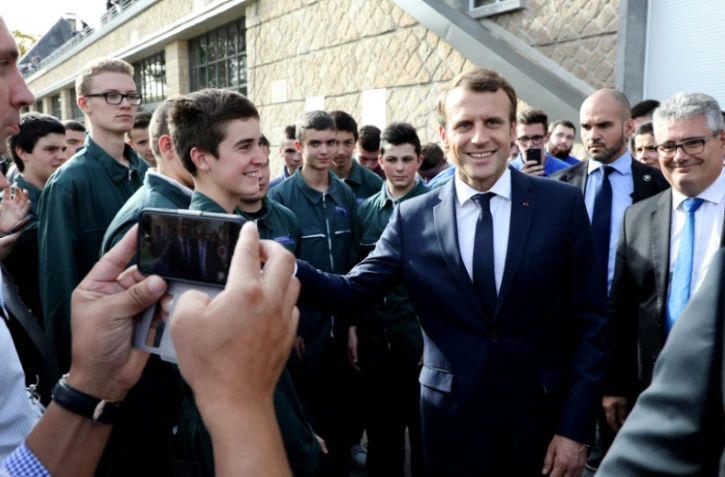 Le président Emmanuel Macron avec des étudiants du nouveau campus de l'Ecole d'application aux métiers des travaux publics (EATP), dédié à l'apprentissage, qu'il visite à Egletons le 4 octobre 2017 
