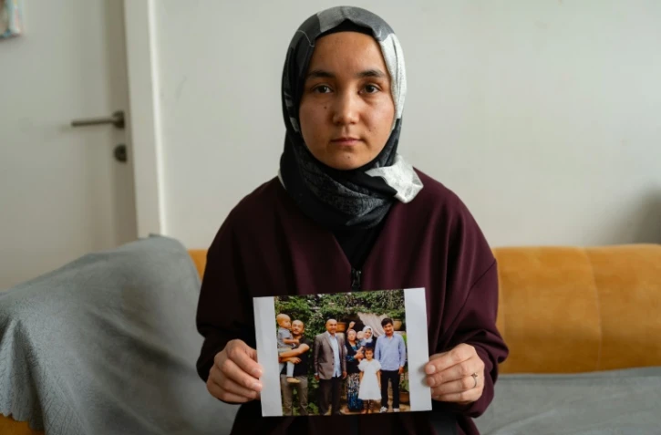 La Ouïghoure Nursimangul Abdureshid montre une photo de sa famille restée en Chine, lors d'une interview avec l'AFP, le 12 mai 2022 à Istanbul, en Turquie