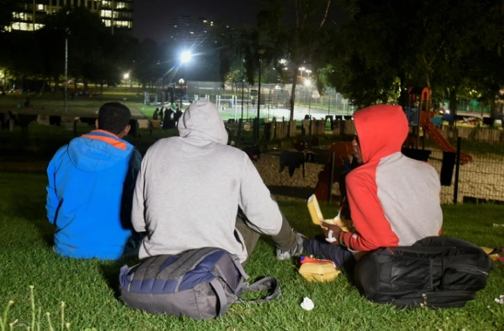 Des migrants et des réfugiés reçoivent de la nourriture d'une ONG dans un parc de Bruxelles le 22 août 2017