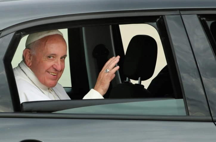 Assis à l'arrière de la Fiat, le pape François salue à son arrivée à Andrews Air Force Base aux Etats-Unis le 22 septembre 2015 